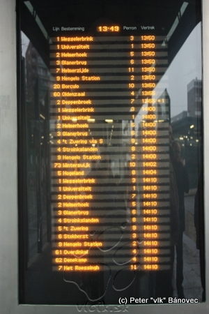 Informačná tabuľa s odchodmi najbližších spojov na stanici v Enschede – údaj s plusom znamená počet minút meškania, ten si cestujúci pripočítava k odchodu podľa CP